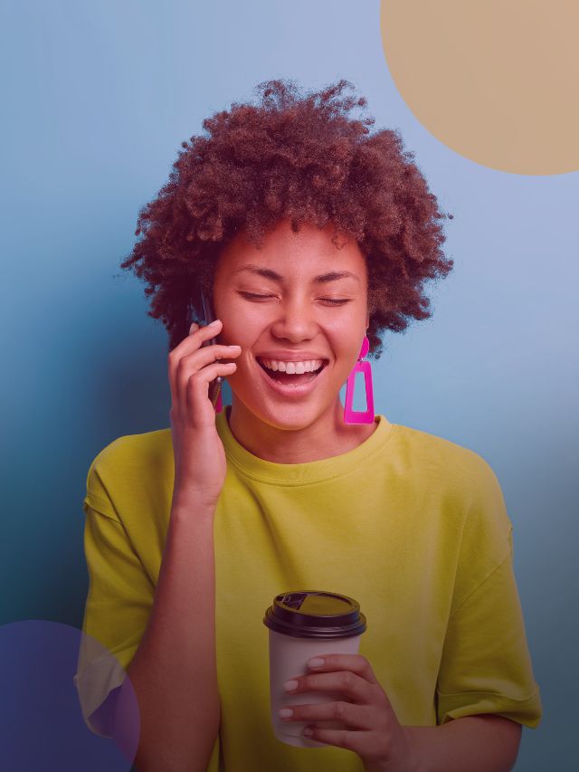 Jovem sorrindo enquanto usa o telefone.
