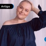 Mulher com camisa azul marinho curada do câncer.