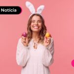 Mulher feliz com uma tiara de coelho de páscoa e segurando ovos coloridos.