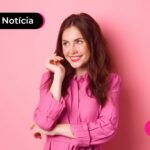 Jovem sorrindo enquanto lê notícia sobre gastos na páscoa de 2025.