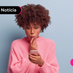 Jovem com expressão de dúvida enquanto usa o celular para pesquisar juros do consignado privado.