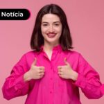 Jovem fazendo sinal de "joinha" com as mãos após ler notícia sobre meutudo e Parati oferecer consignado privado.