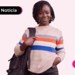 Jovem estudante sorrindo enquanto segura mochila.
