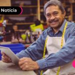 Pessoa sorrindo enquanto segura documento do INSS.