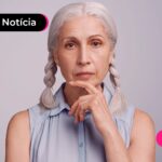 Aposentada do INSS com mão no queixo e expressão de dúvida pensando sobre o pagamento do 14º salário do INSS.