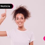 Jovem negativado sorrindo após ler notícia sobre trocar dívida e limpar o nome com o consignado privado.