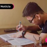 Pessoa com roupa preta estudando pelos livros.