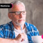 Pessoa idosa olhando para frente pensativa, enquanto apoia a caneta no queixo.
