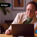 Idoso mexendo no computador enquanto segura oculos