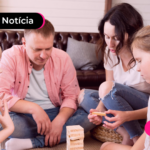 Pessoas brincando com jogo de madeira com crianças.
