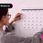 Mulher colocando calendário na parede