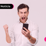 Pessoa de camisa social olhando celular com expressão animada.