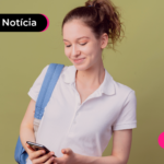 Pessoa jovem de mochila e camisa branca olhando para o celular.