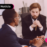 Pessoas de terno olhando um para outro enquanto analisam gráfico no computador.