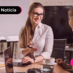 Pessoas conversando enquanto estão com notebook aberto.