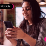 Pessoa de blusa xadrez olhando para o celular com expressão feliz.