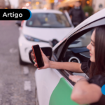 Pessoa no carro segurando um celular.