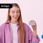 Mulher segurando um cartão e um celular.