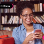 Pessoa olhando para o celular com expressão feliz.