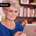Pessoa idosa olhando para tela de tablet com expressão feliz.