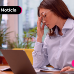 Pessoa com notebook aberto com a mão na testa.