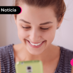 Pessoa com expressão alegre olhando para celular.