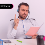 Pessoa de blusa social olhando para agenda enquanto está em ligação.