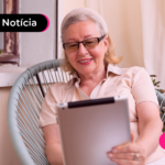 Pessoa idosa olhando para tablet com expressão feliz.