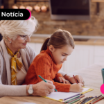 Pessoa idosa pintando em papel junto com criança.