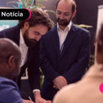 Pessoas de terno analisando algo em mesa.