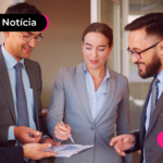 Pessoas de terno analisando algo em papel.
