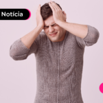 Pessoa de camisa social cinza com as mãos na cabeça.