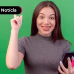 Mulher feliz segurando o celular.
