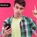 Pessoa de camisa xadrez segurando celular e apontando para cima.
