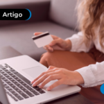 pessoa mexendo no computador e segurando o cartão
