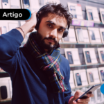 Homem segurando o seu celular novo.