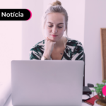 Pessoa em escritório olhando para computador com expressão pensativa.