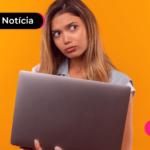 Pessoa com expressão confusa enquanto segura notebook.