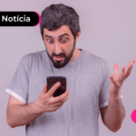 Pessoa de blusa cinza olhando com expressão surpresa para celular.