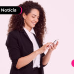 Pessoa de roupa social sorrindo enquanto mexe em celular.