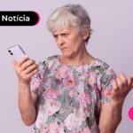 Idosa olhando para o celular com expressão de dúvida.