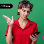 Pessoa jovem lendo sobre fake news do WhatsApp Gold.