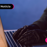 Pessoa de casaco e luvas pretas mexendo em computador.