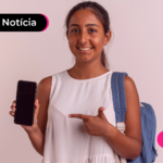 Adolescente com mochila azul apontando para celular com expressão feliz.