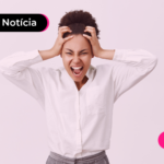 Pessoa de blusa branca com as duas mãos na cabeça e de boca aberta.