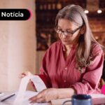 Idosa lendo papéis de taxas de juros.