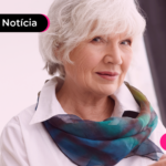 Pessoa idosa segurando celular com expressão feliz.