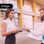 Homem entrega documentos a uma mulher em ambiente externo, simbolizando contrato.