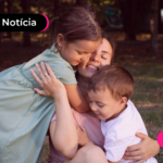 Pessoa em parque brincando com duas crianças.