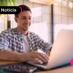 Pessoa olhando para notebook com expressão feliz.